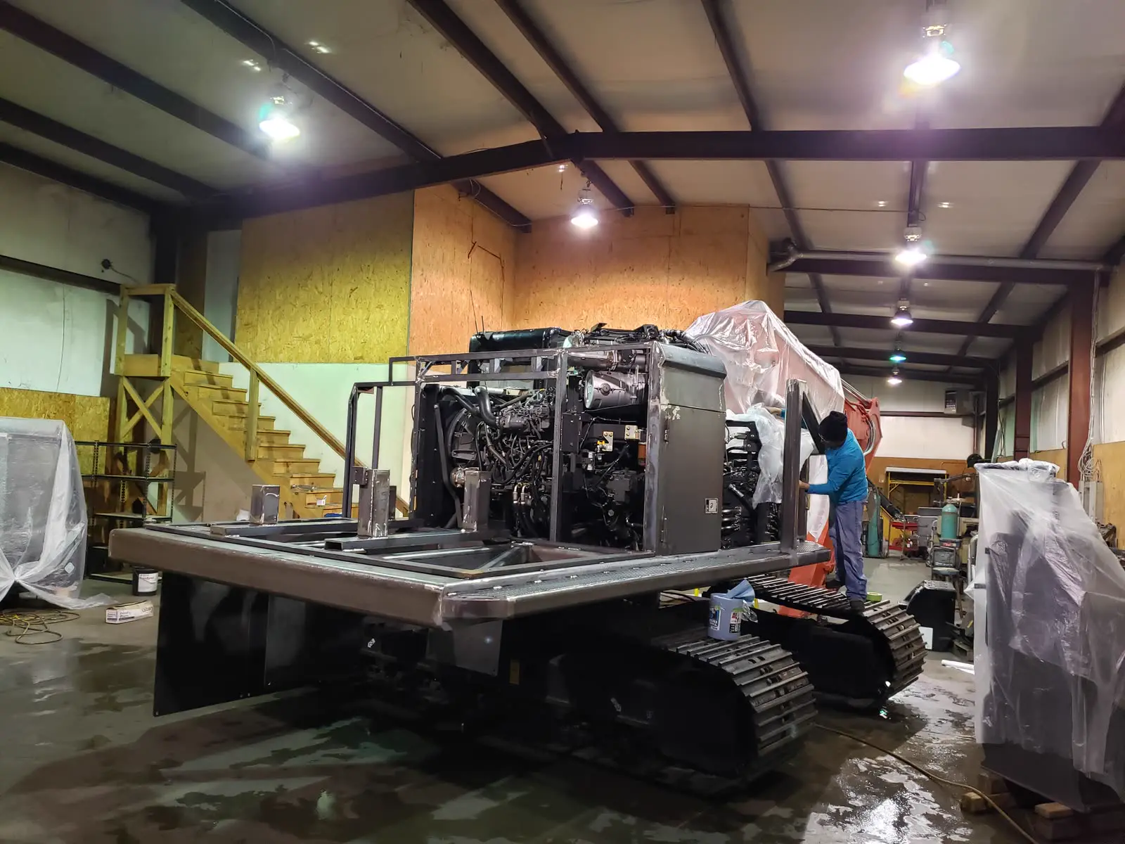 Powertek power pack mid-build in the Concord shop, bare frame and engine exposed, technician working