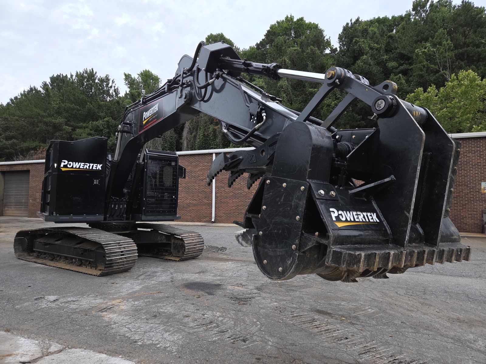 Powertek XPE excavator holding a Powertek mulching cutterhead raised, drum teeth visible