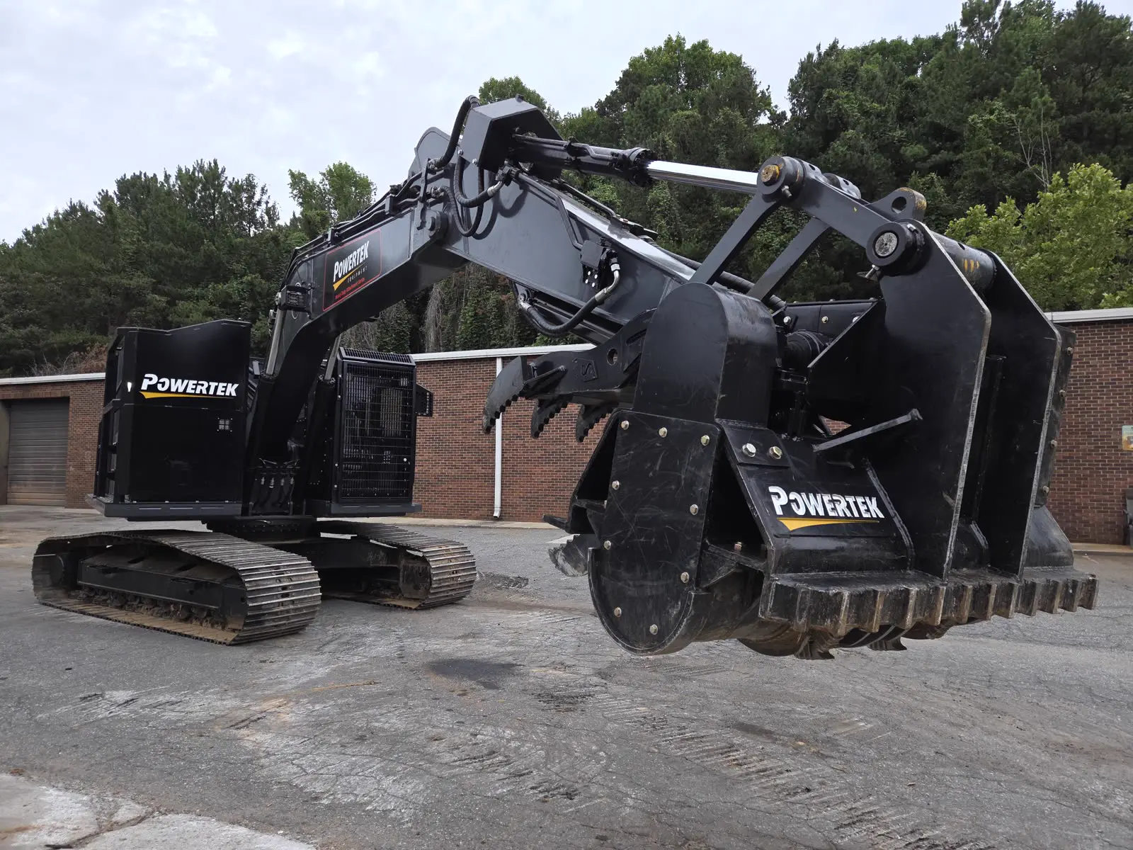 Powertek XPE excavator holding a Powertek mulching cutterhead raised, drum teeth visible